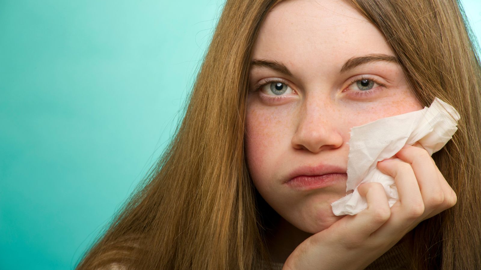 Donna con occhi arrossati e fazzoletto a causa di allergia al polline, si appresta a effettuare test ematico.